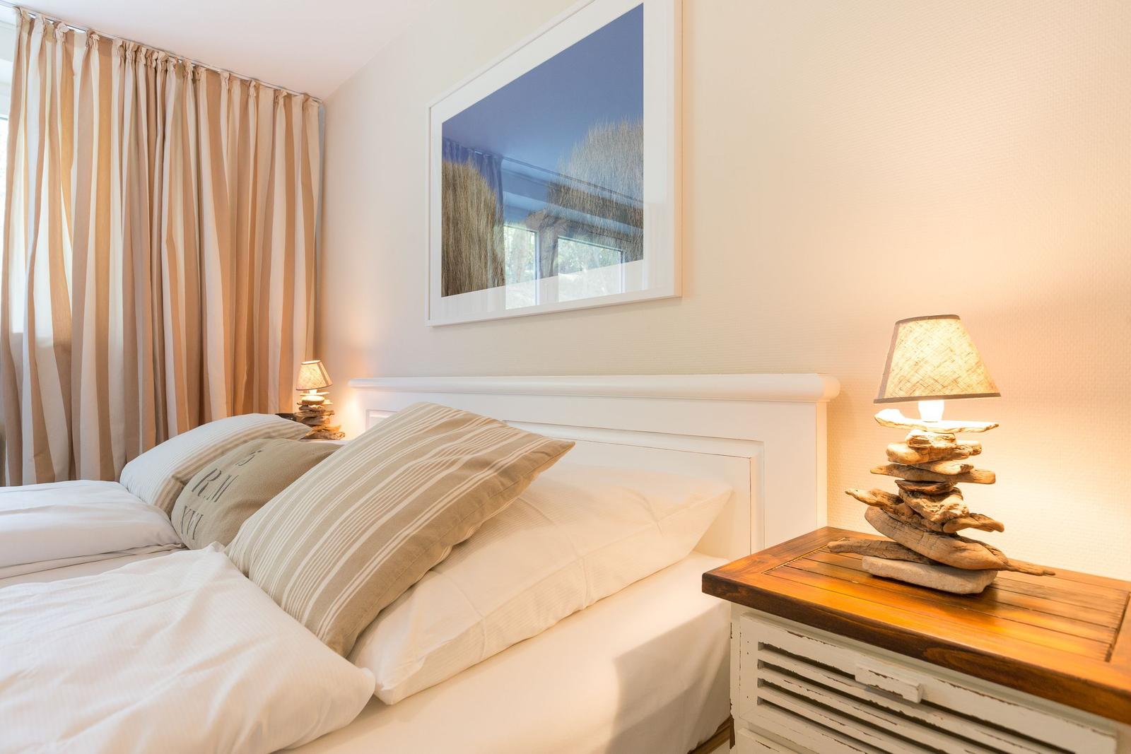 Bedroom with bed, nightstand, and wall picture