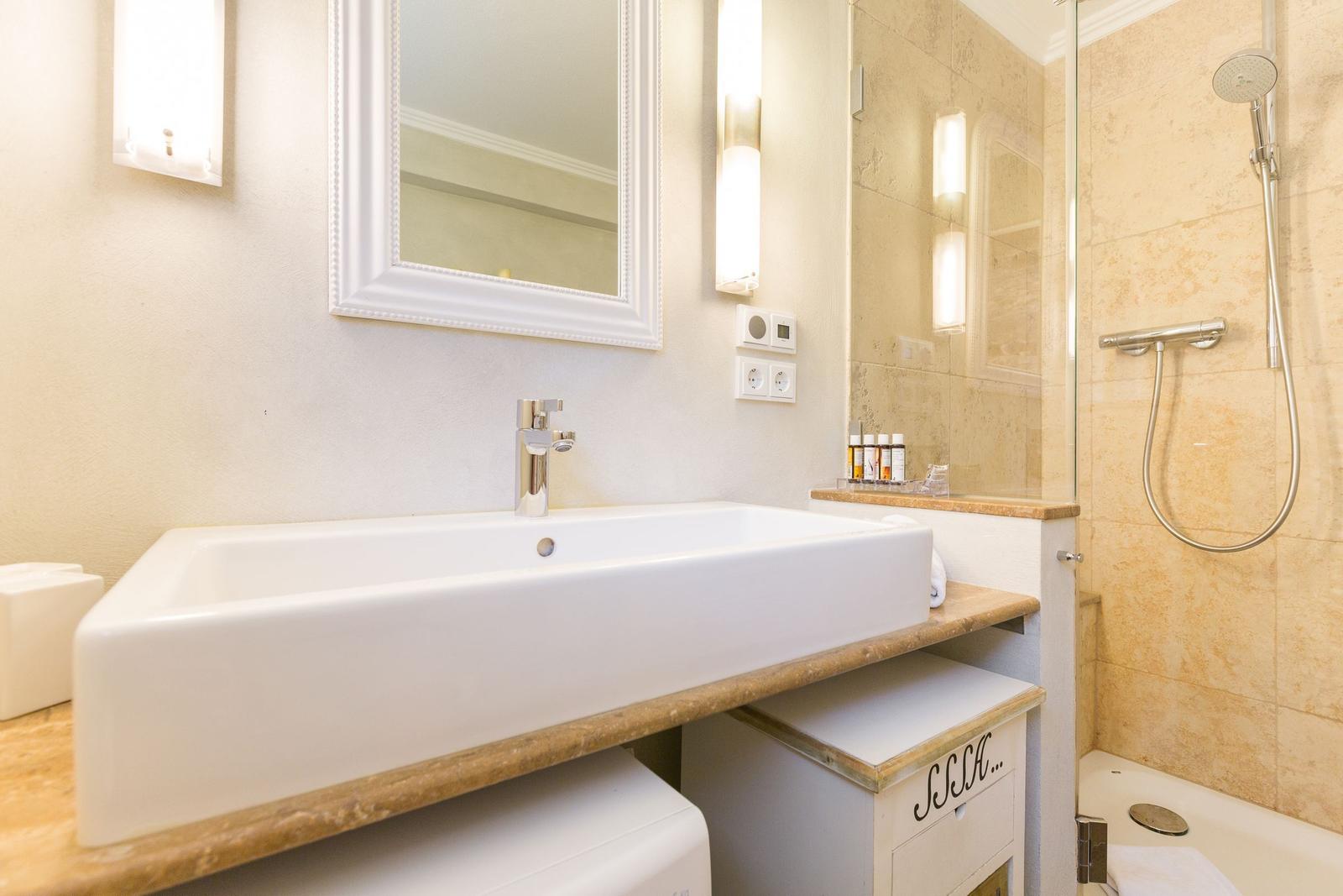Bathroom with sink, mirror, and shower.