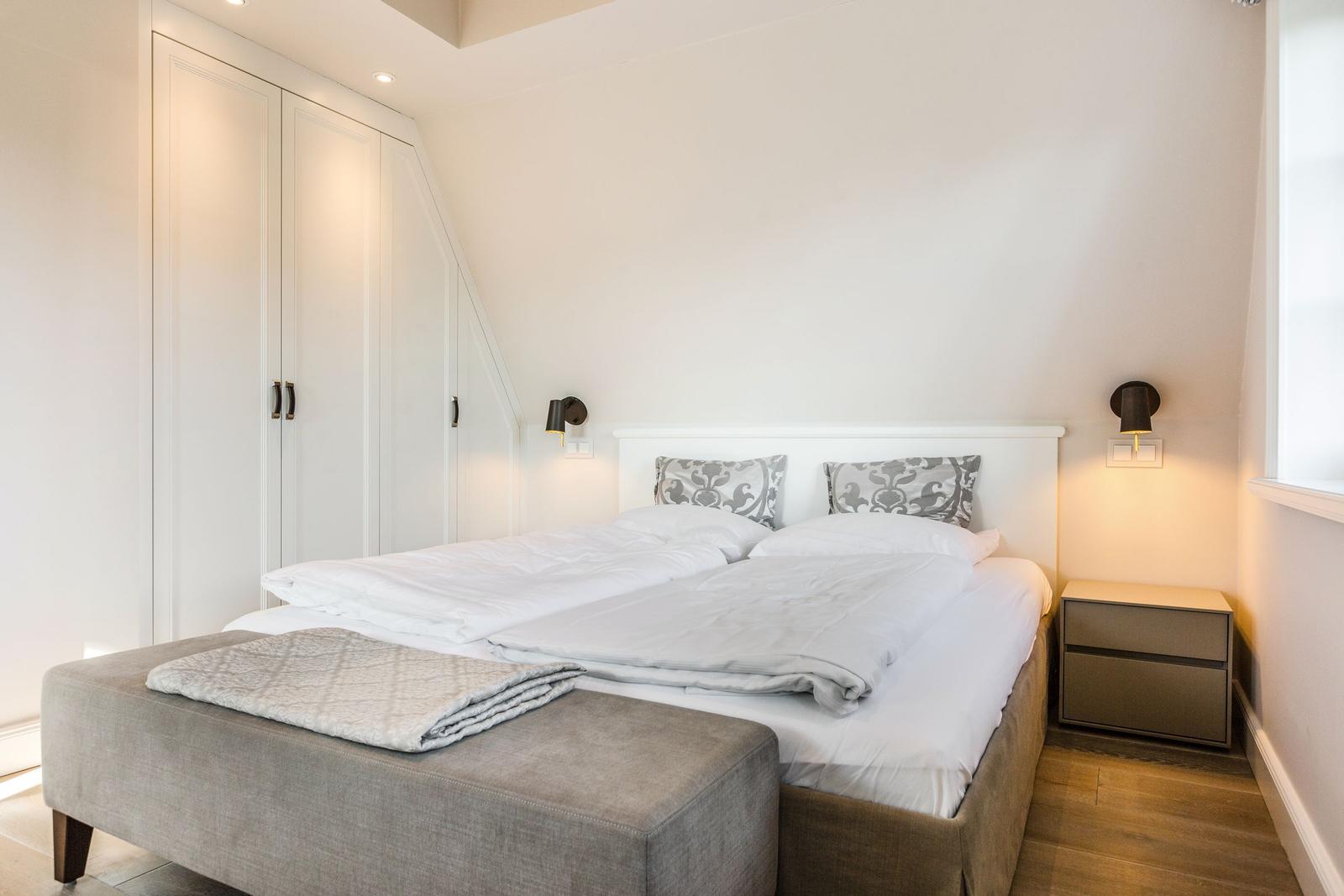 Schlafzimmer mit Doppelbett, Kleiderschrank und Nachttisch.