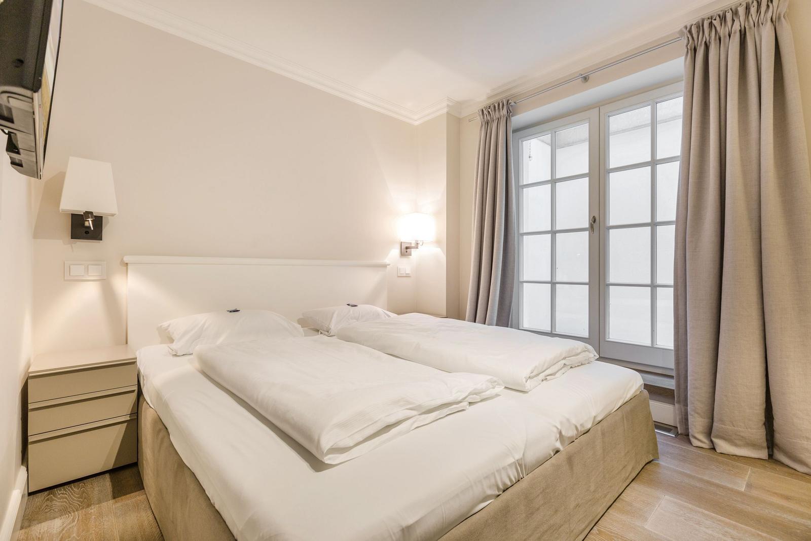 Schlafzimmer mit Doppelbett, Fenster und Nachttischen