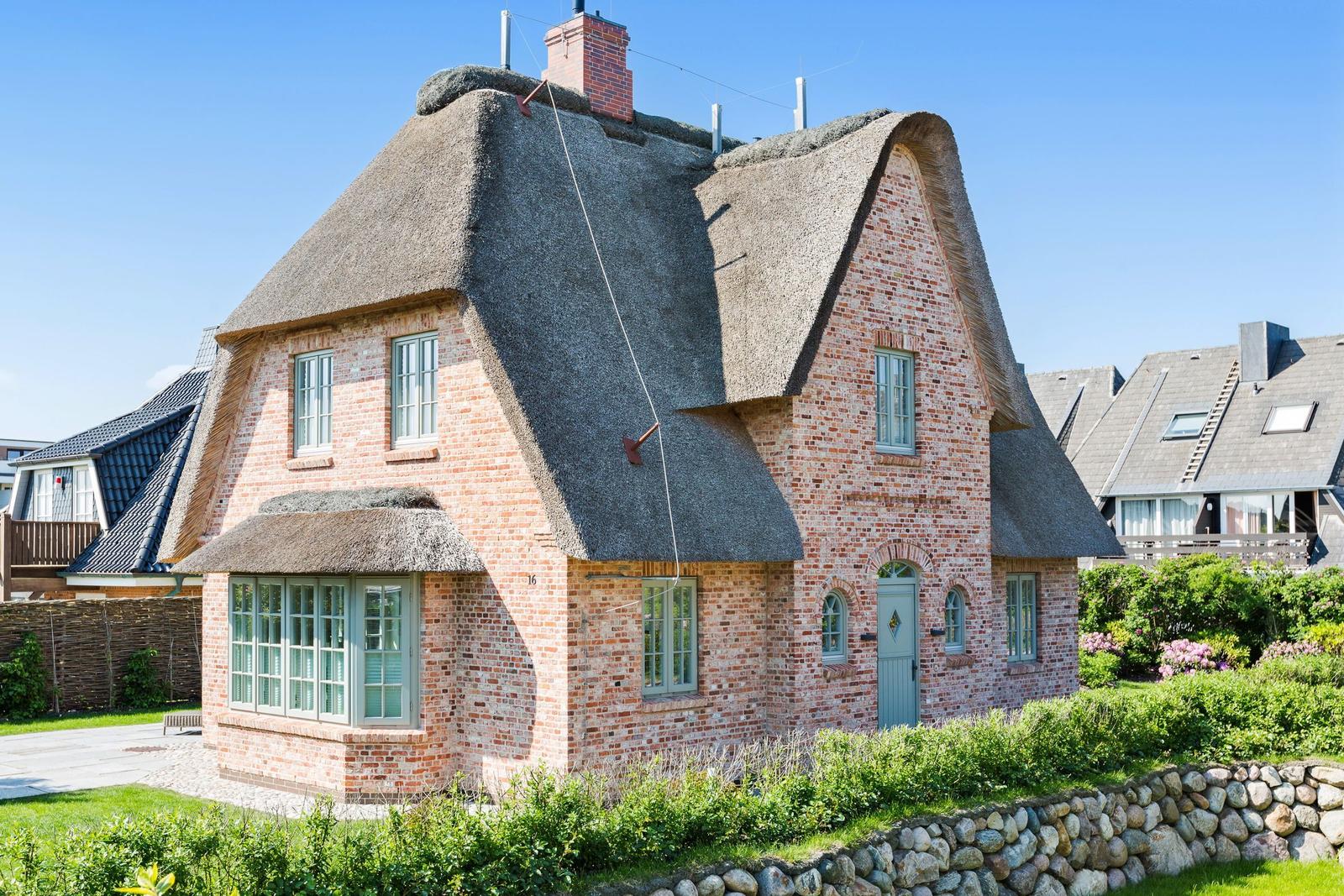 Haus mit Strohdach, Backsteinfassade und grüner Tür