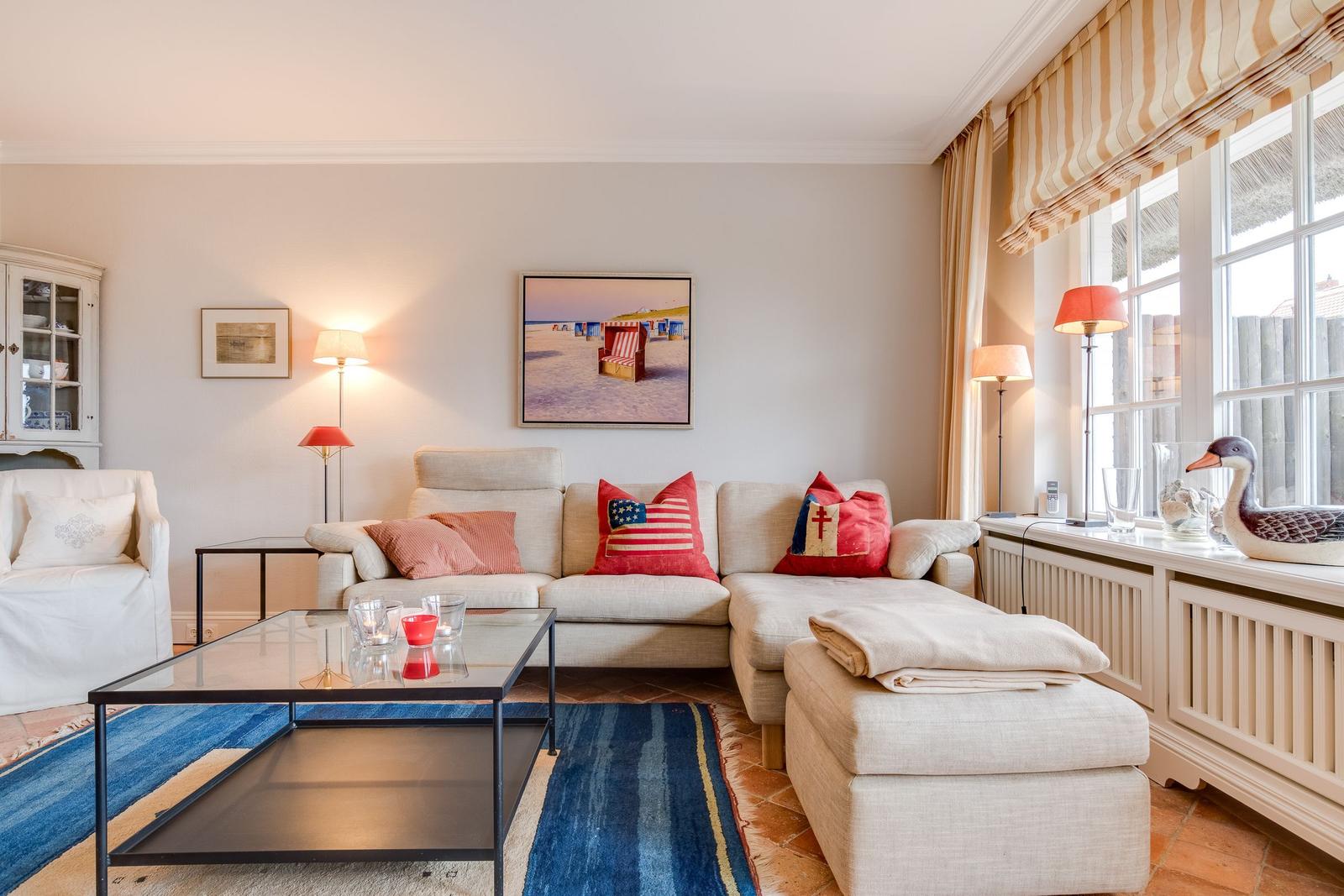 Wohnzimmer mit Sofa, Couchtisch und Fenster mit Jalousie.