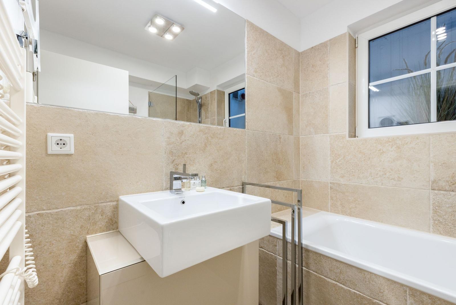 Bathroom with sink, bathtub, and mirror