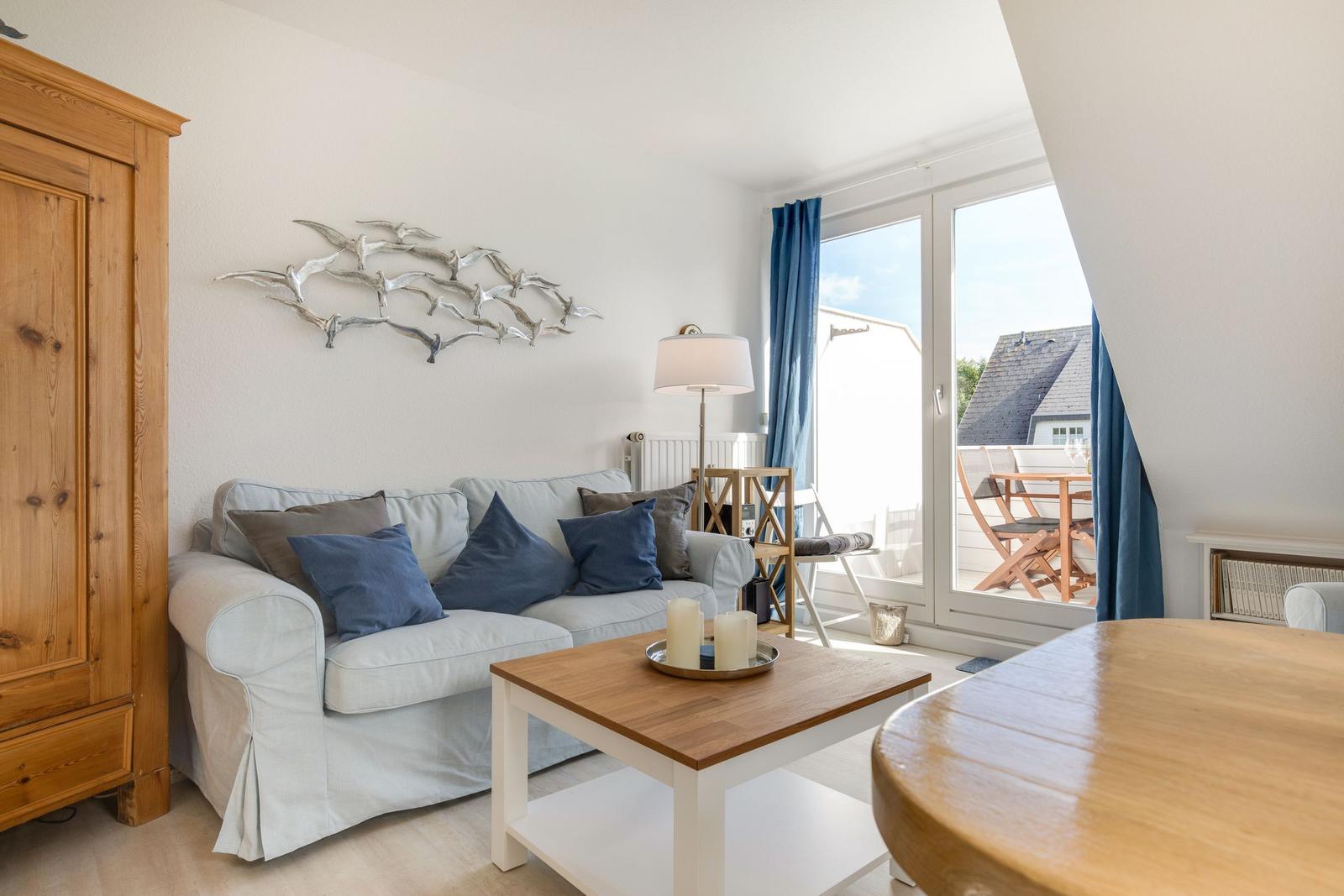 Wohnzimmer mit Sofa, Couchtisch und Blick auf Balkon