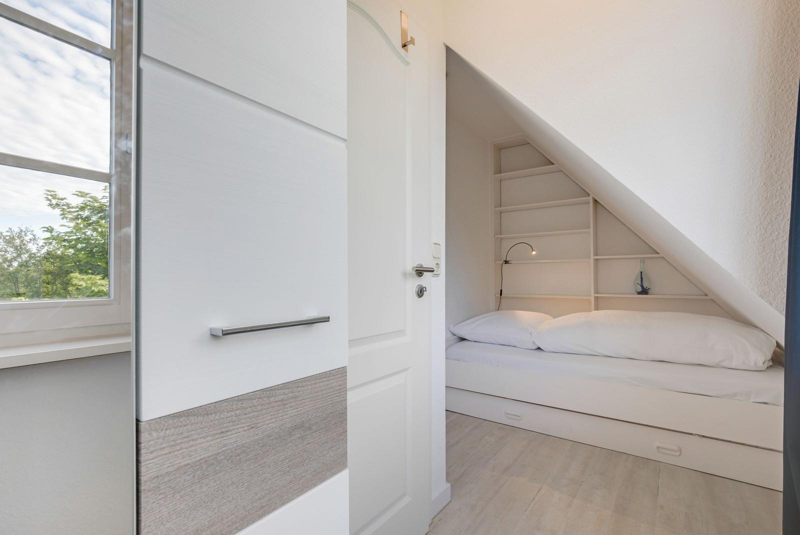 Schlafzimmer mit Dachschräge, Bett und Regal
