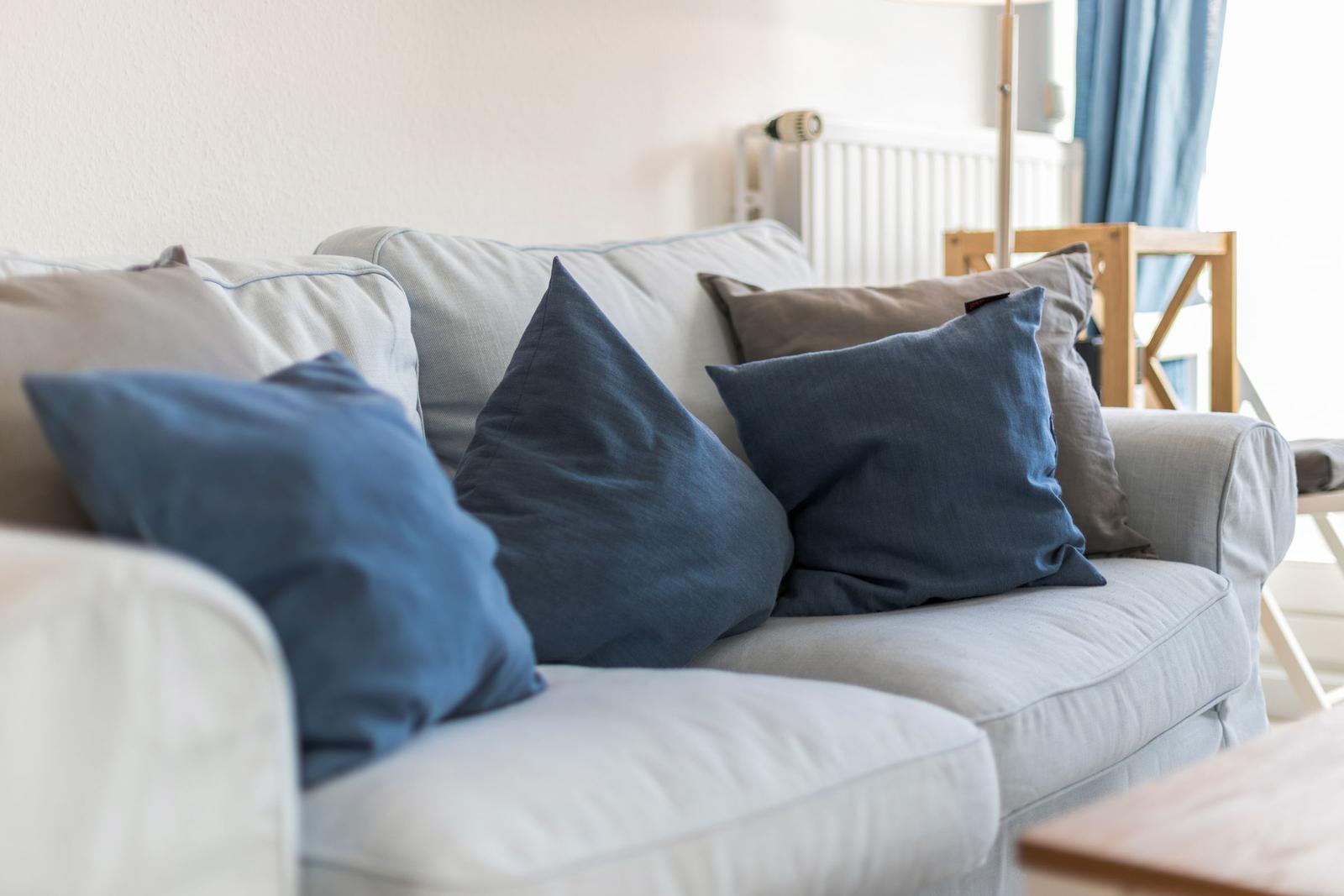 Ein Sofa mit blauen und grauen Kissen im Wohnzimmer