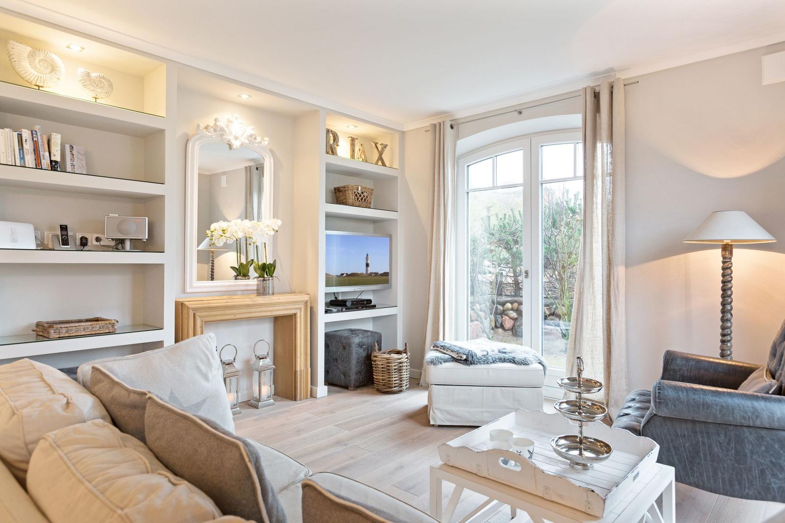 Wohnzimmer mit Sofa, Fernseher und Blick auf Garten