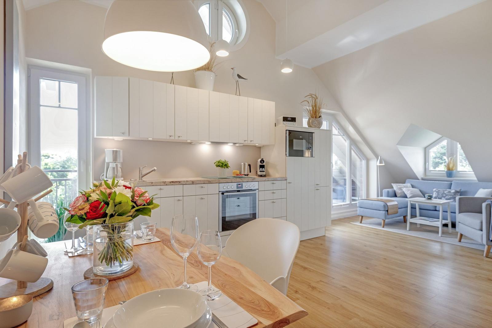 Kitchen with dining area and living room under sloped ceilings.