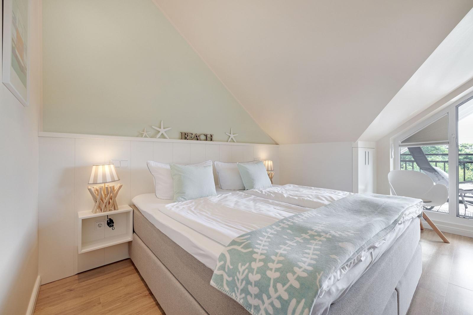 Bedroom with double bed, bedside table, and balcony view.