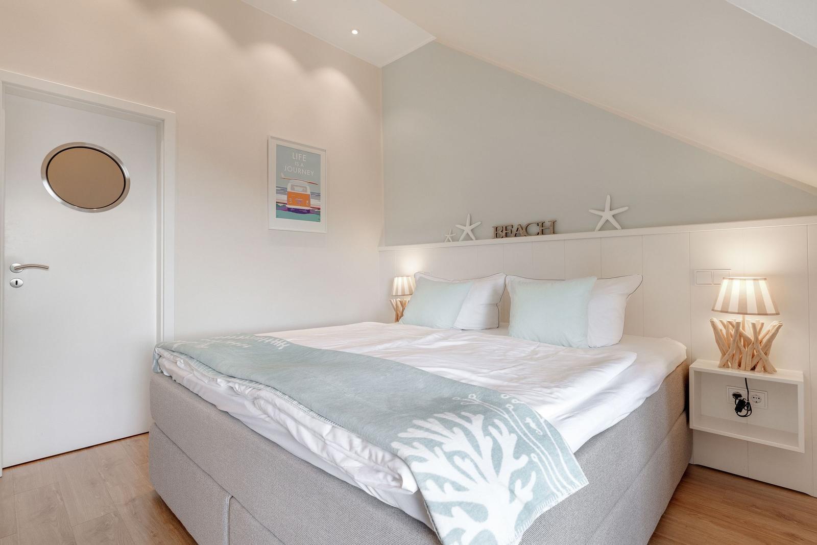 Bedroom with bed, nightstand, and wall decoration.