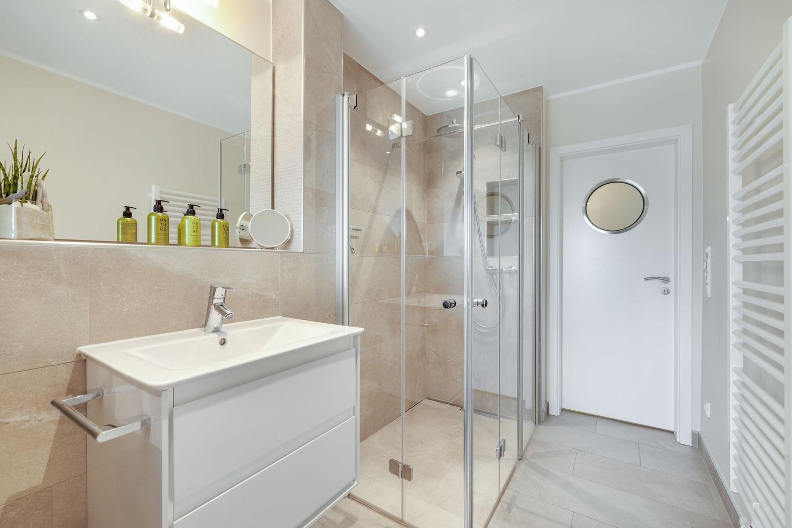 Bathroom with shower, sink, and mirror.