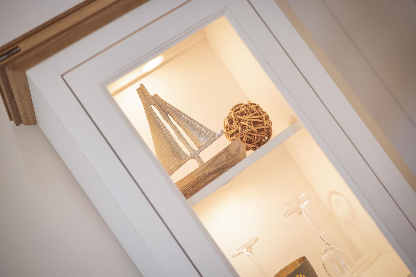A lit cabinet with sailboat and ball decoration