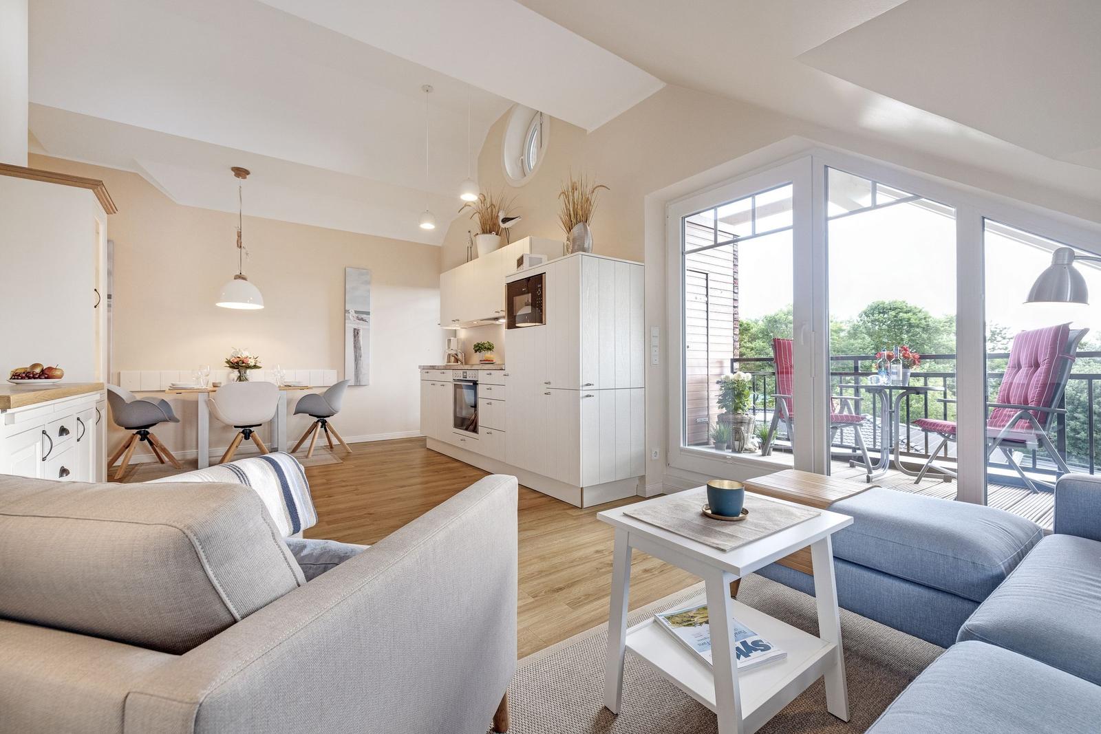 Living room with kitchen and balcony. Modern furnishings and wooden floor.