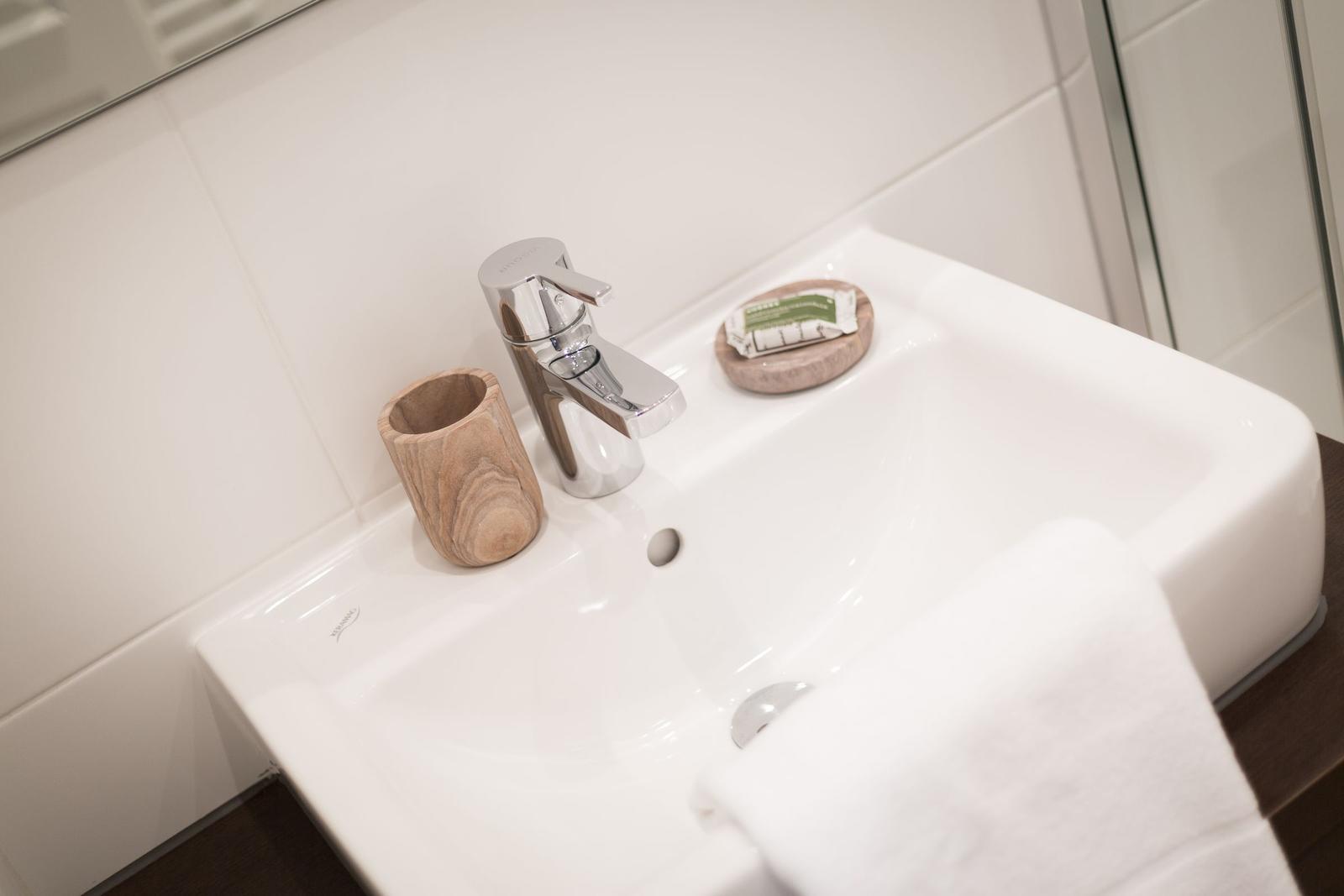 Waschbecken mit Wasserhahn, Seifenspender und Handtuch