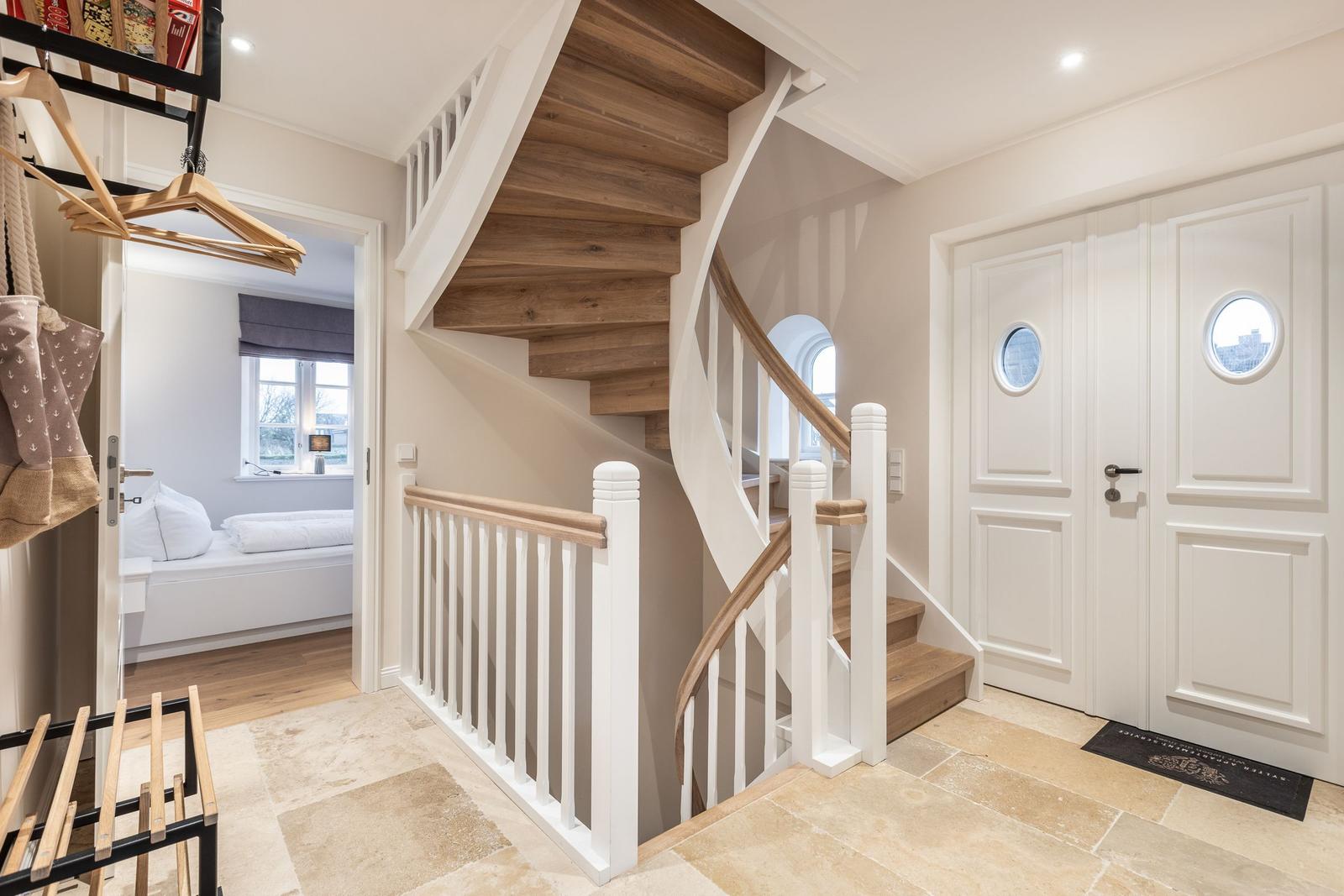 Haus mit Wendeltreppe, Eingangstüren mit runden Fenstern und Blick in Schlafzimmer.