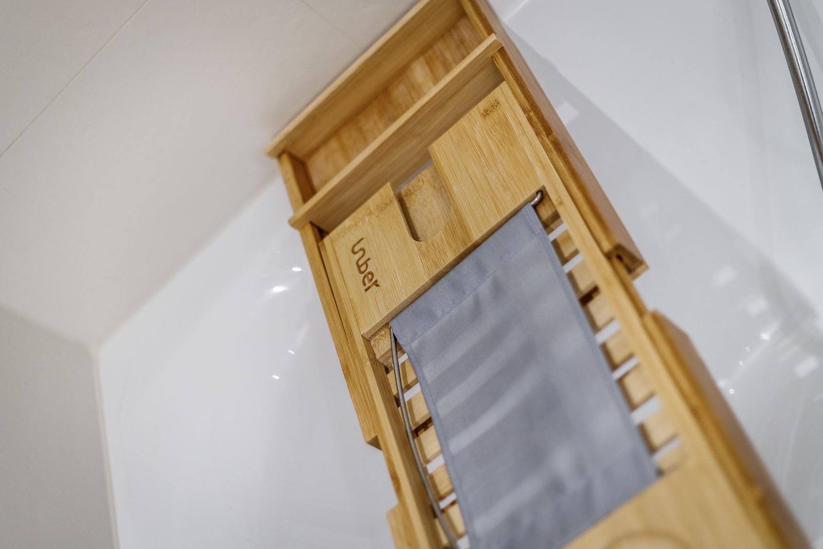 Holzhandtuchhalter mit grauem Handtuch in Bad