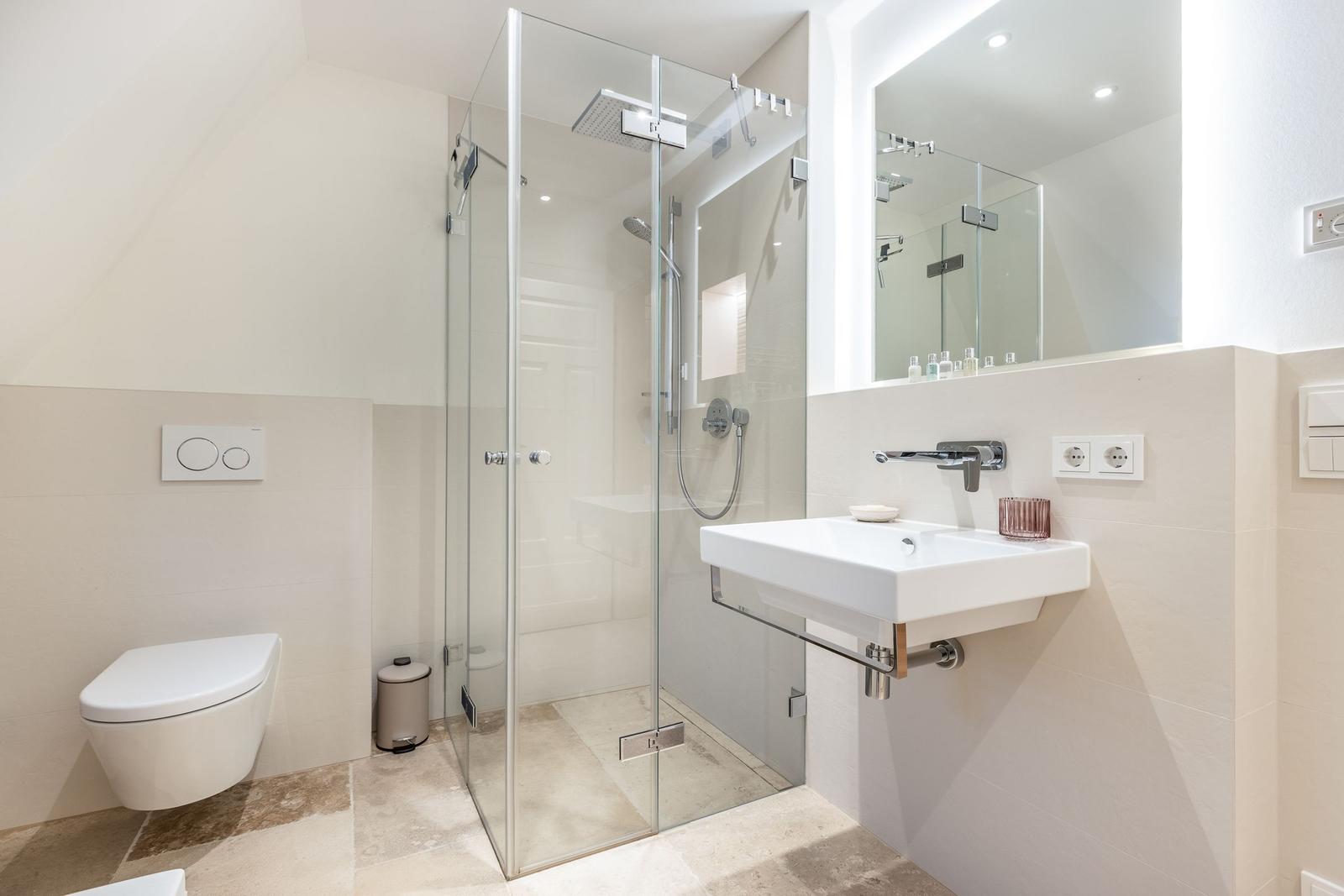Moderne Badezimmer mit Dusche, Waschbecken und Toilette.
