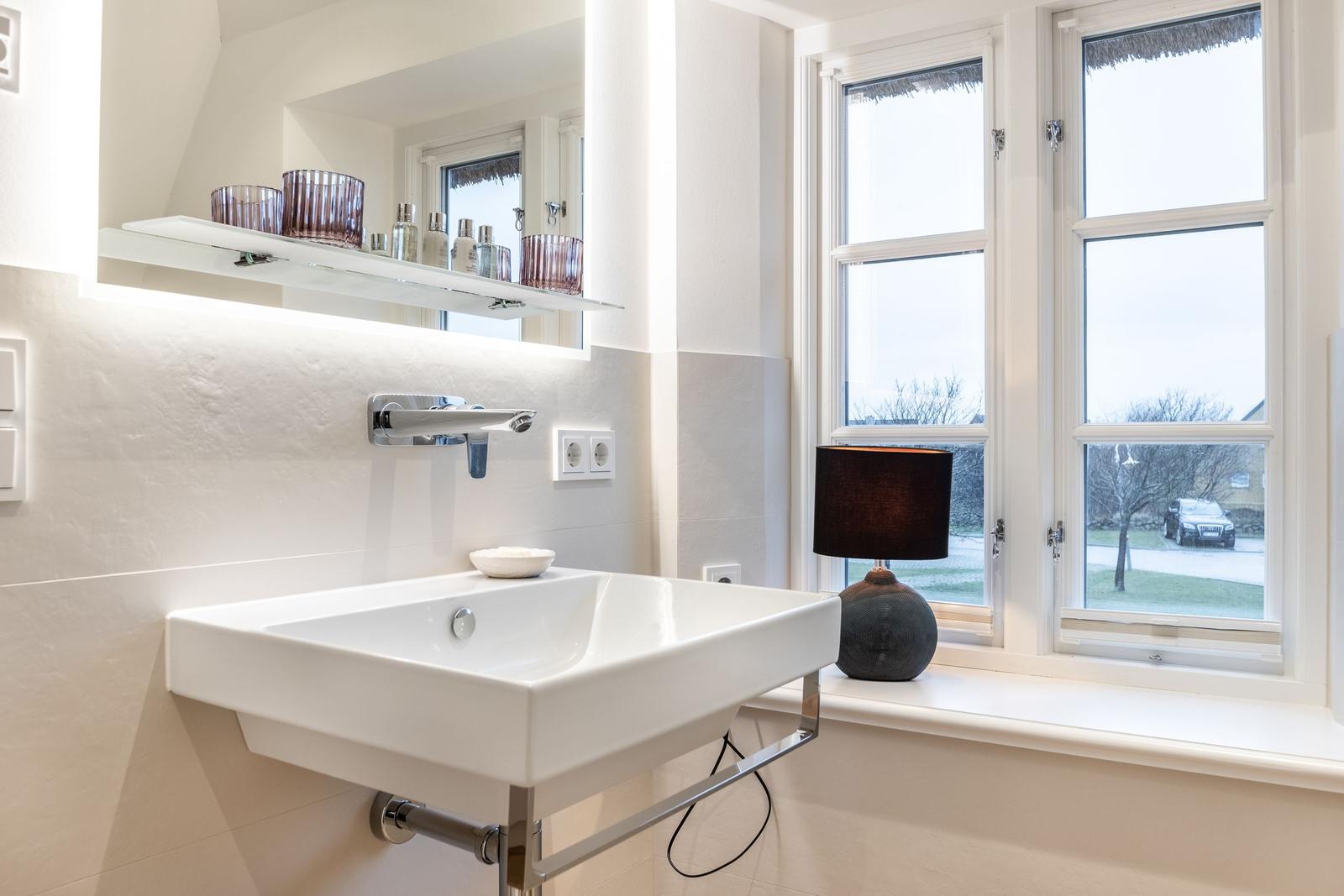 Waschbecken mit Spiegel und Fensterblick