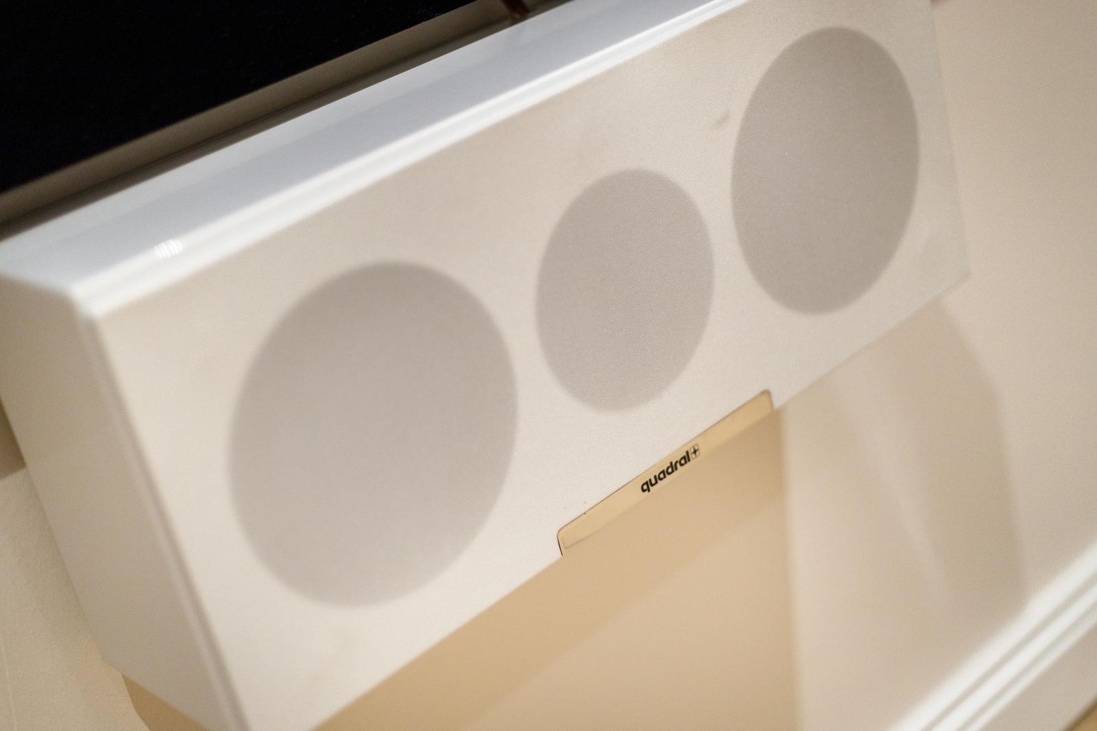Weißer Lautsprecher mit drei runden Membranen an der Wand