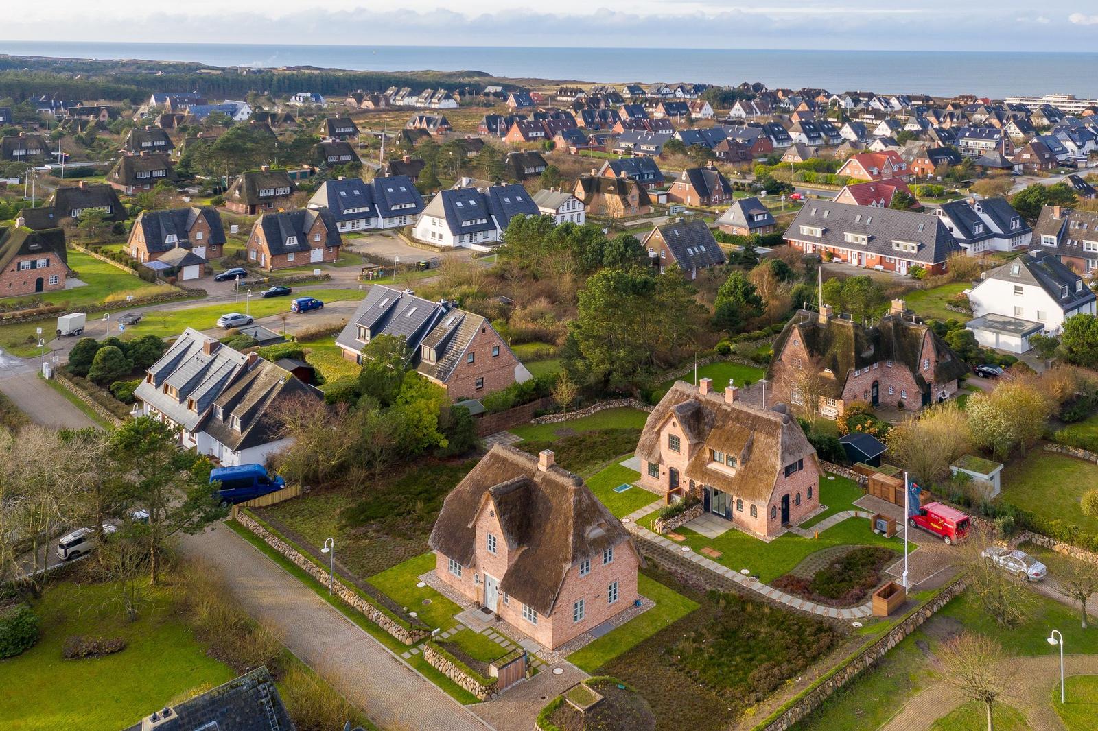 Dorf mit strohgedeckten Häusern und Blick aufs Meer