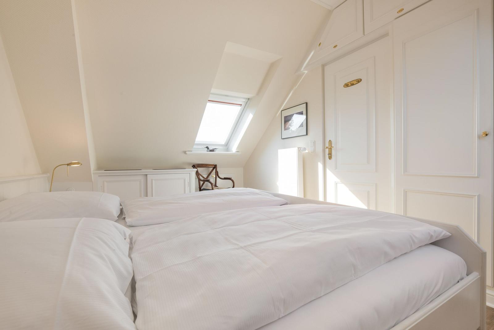 Bedroom with skylight, bed, and wardrobe.