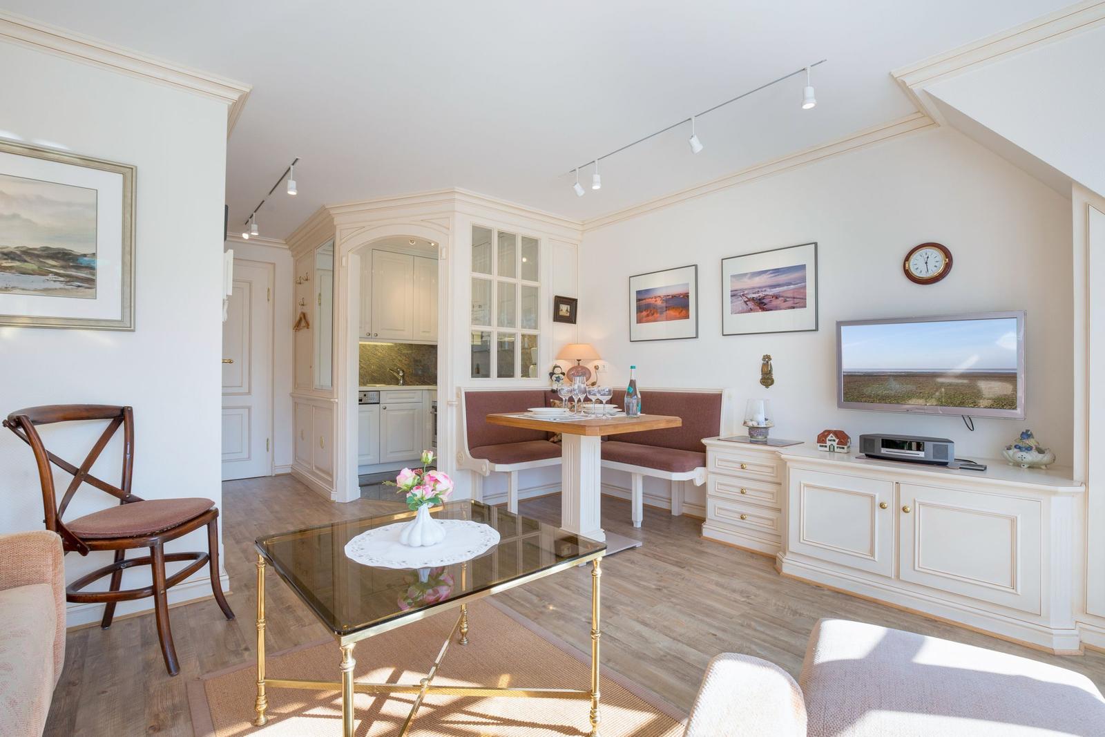 Living and dining area with TV, dining table, and kitchen area.