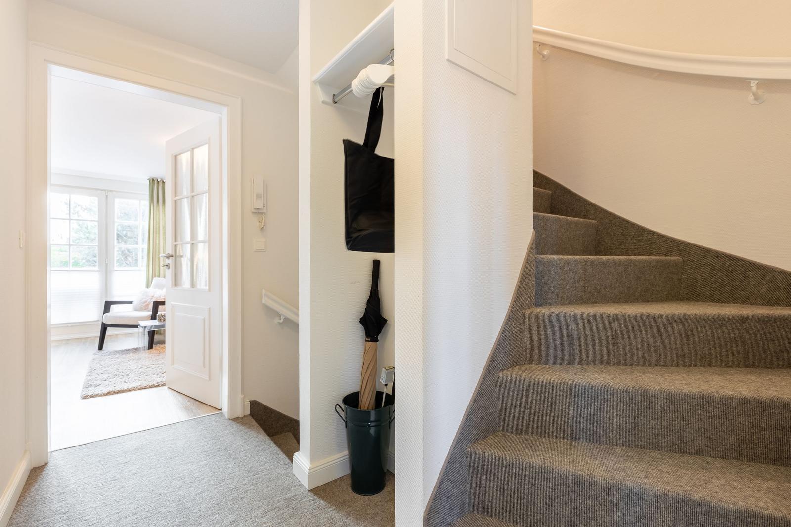 Staircase with carpeted steps, closet, and entrance to living area.