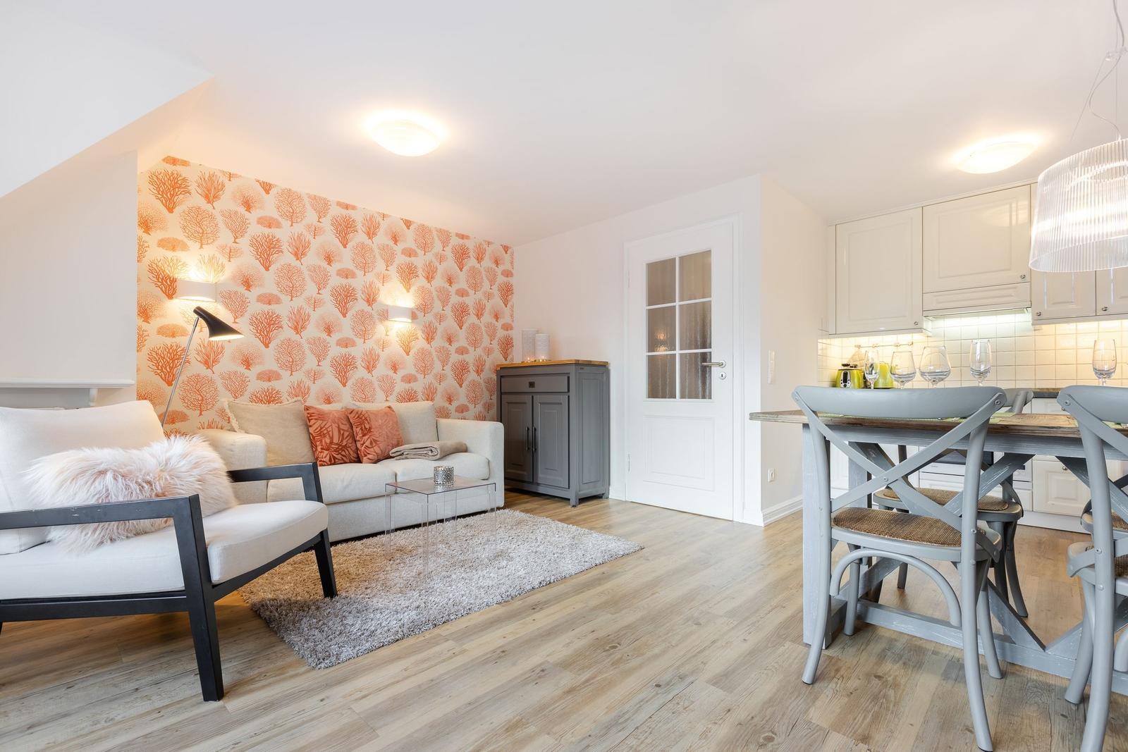 Living and dining area with sofa, table, and kitchenette.