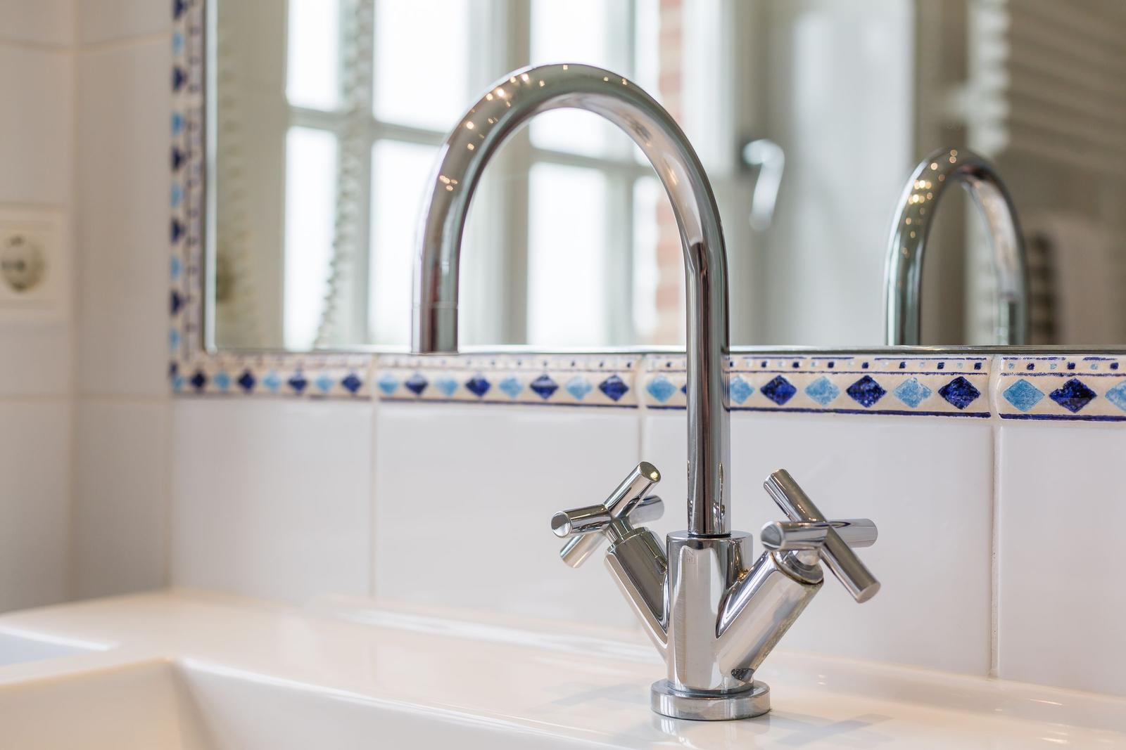 Bathroom with chrome faucet and blue-white tiles