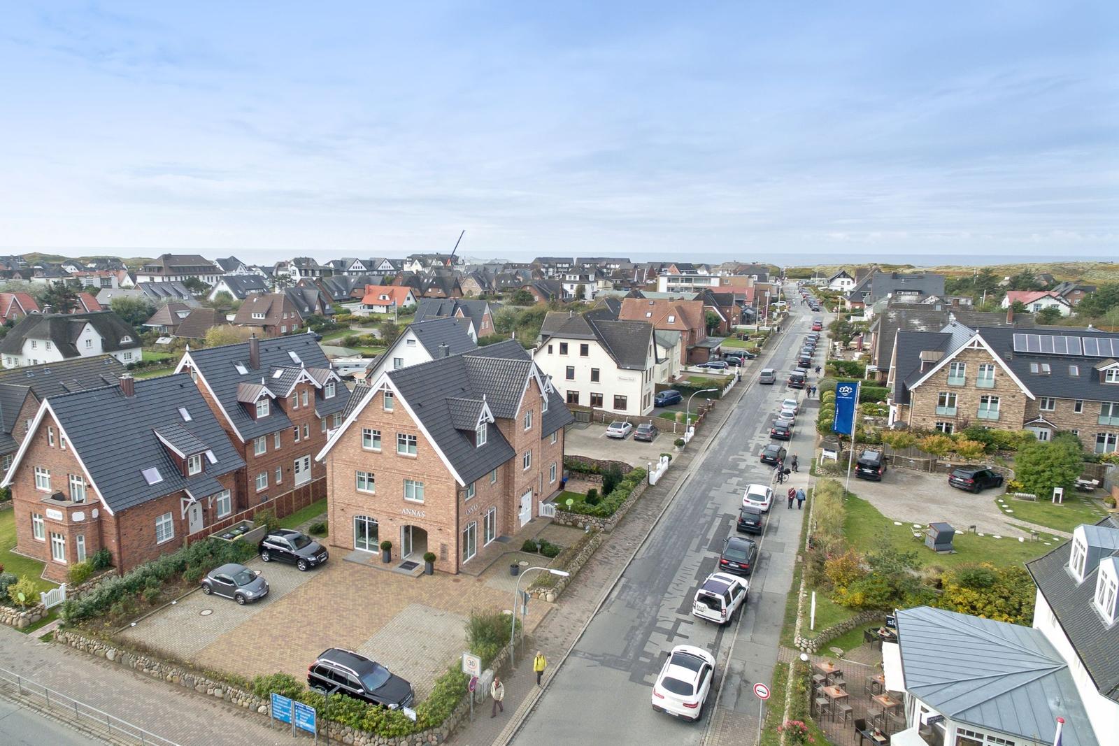City view with houses, streets, and sea in the background.