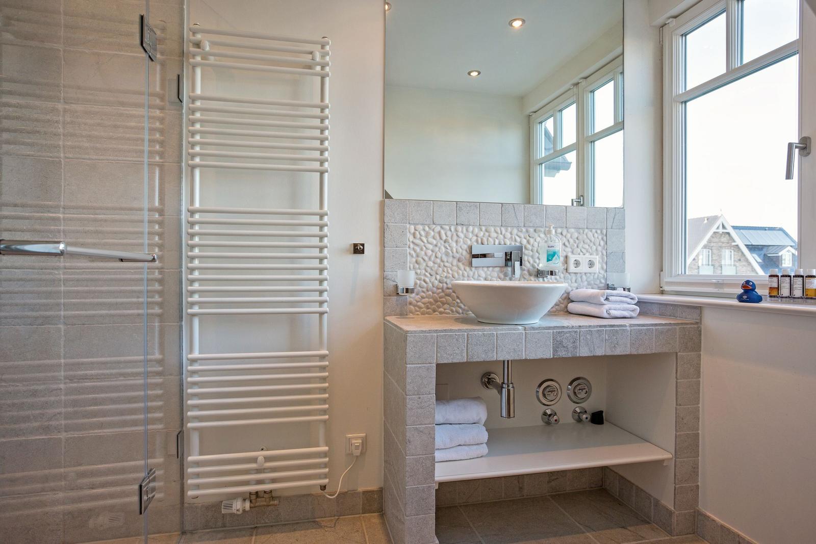 Bathroom with shower, sink, and window