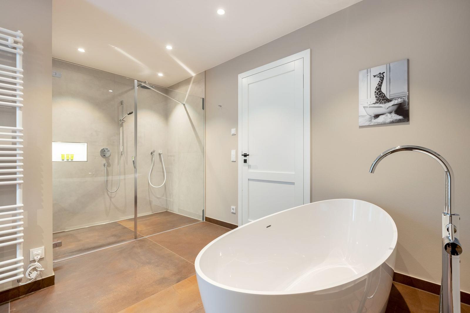 Bad mit freistehender Badewanne und Dusche mit Glaswand