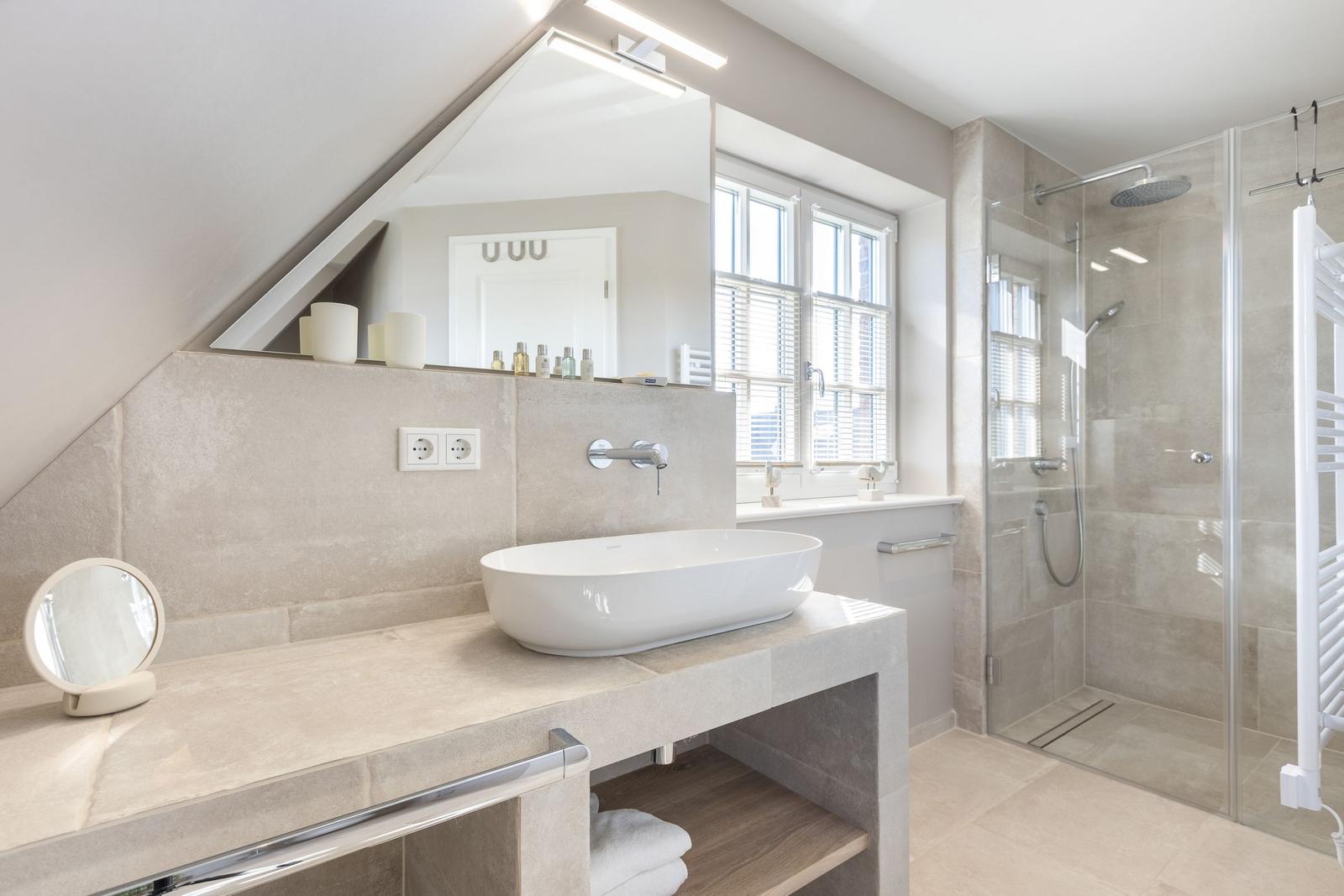 Bathroom with shower, sink, and window