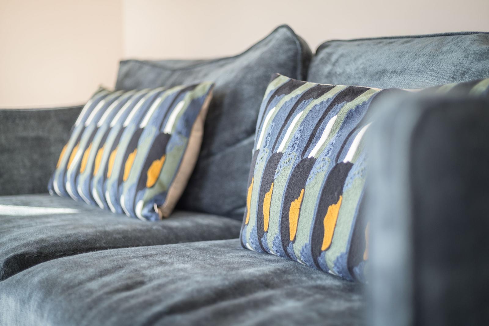 A sofa with two pillows in striped pattern.