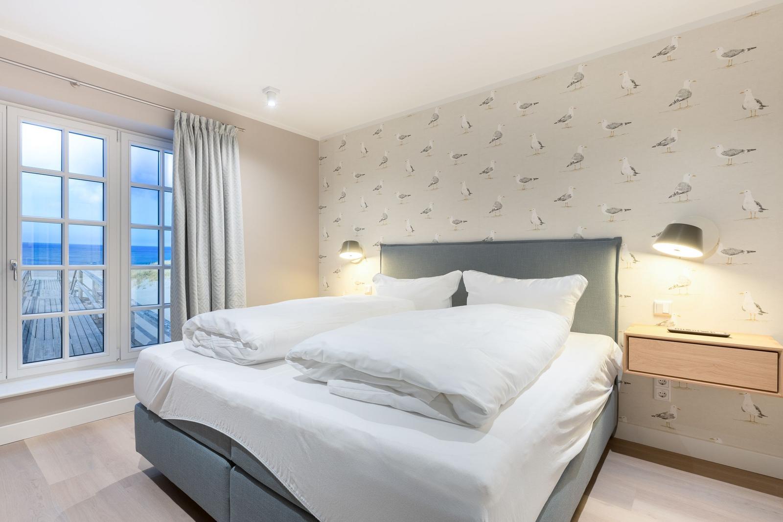 Bedroom with sea view and seagull wallpaper.