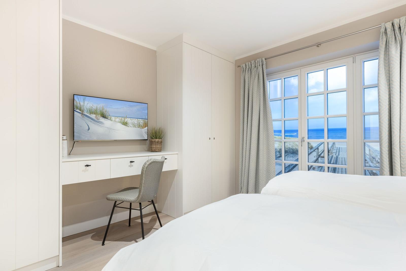 Bedroom with sea view and desk with TV