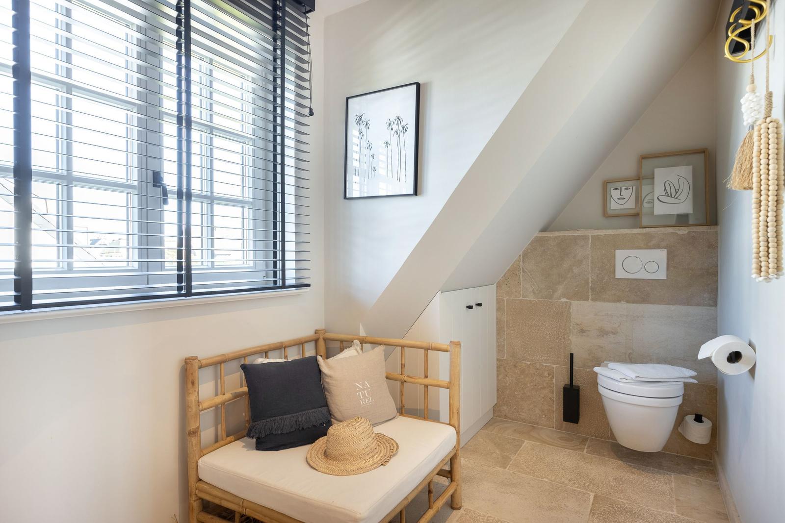 Shower with bamboo bench, window and stone tiles