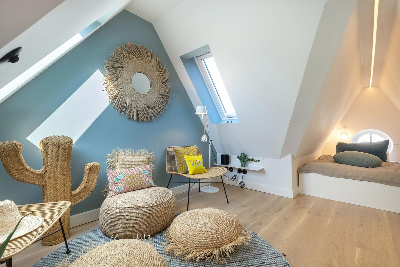 Attic room with daybed, seating area, and sloped ceiling.