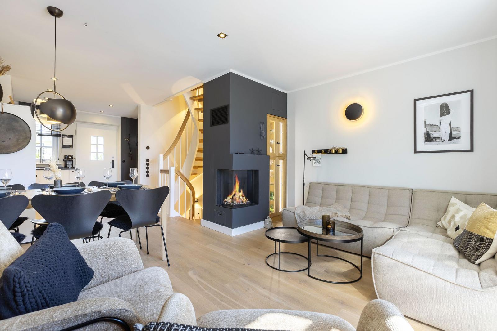 Living and dining area with fireplace, sofa, and table.