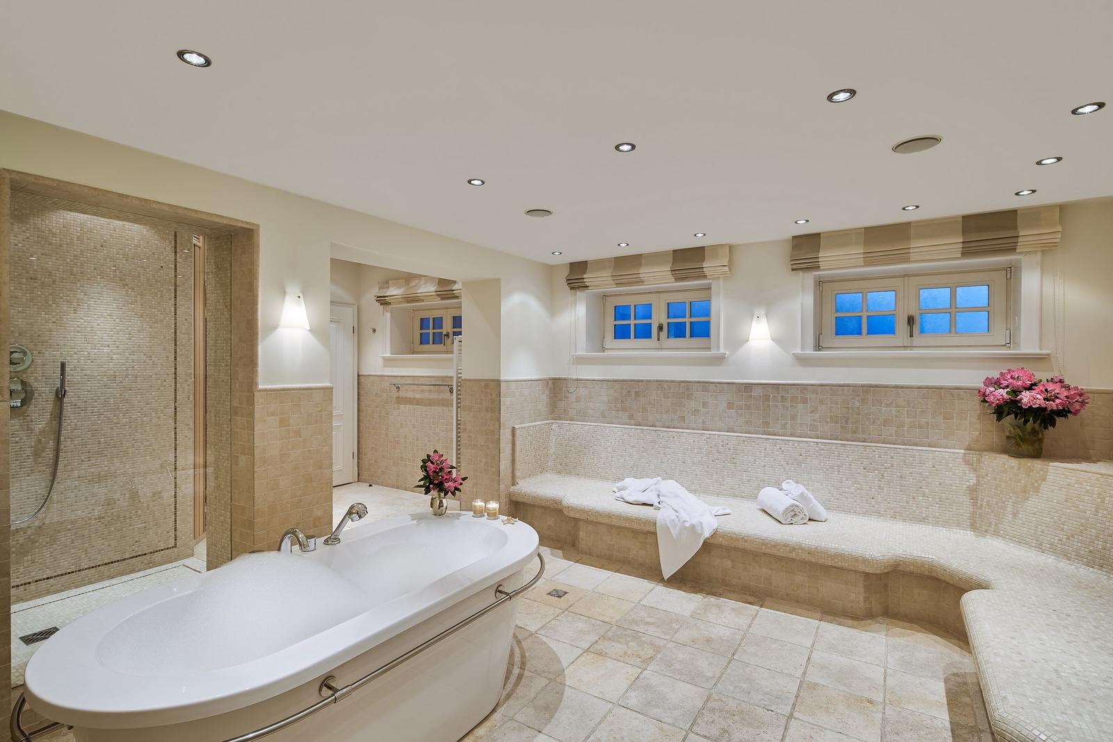 Bath with whirlpool, shower, and seating area with windows