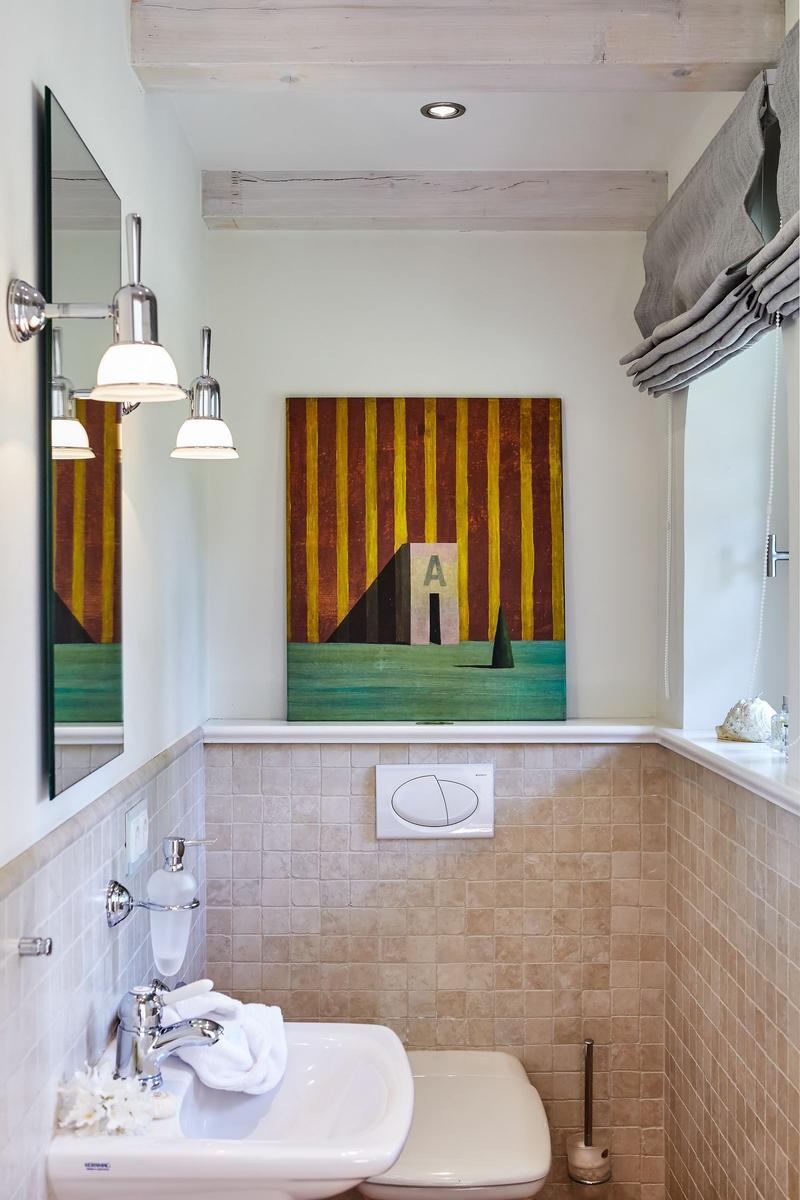Bathroom with sink, toilet, and wall art