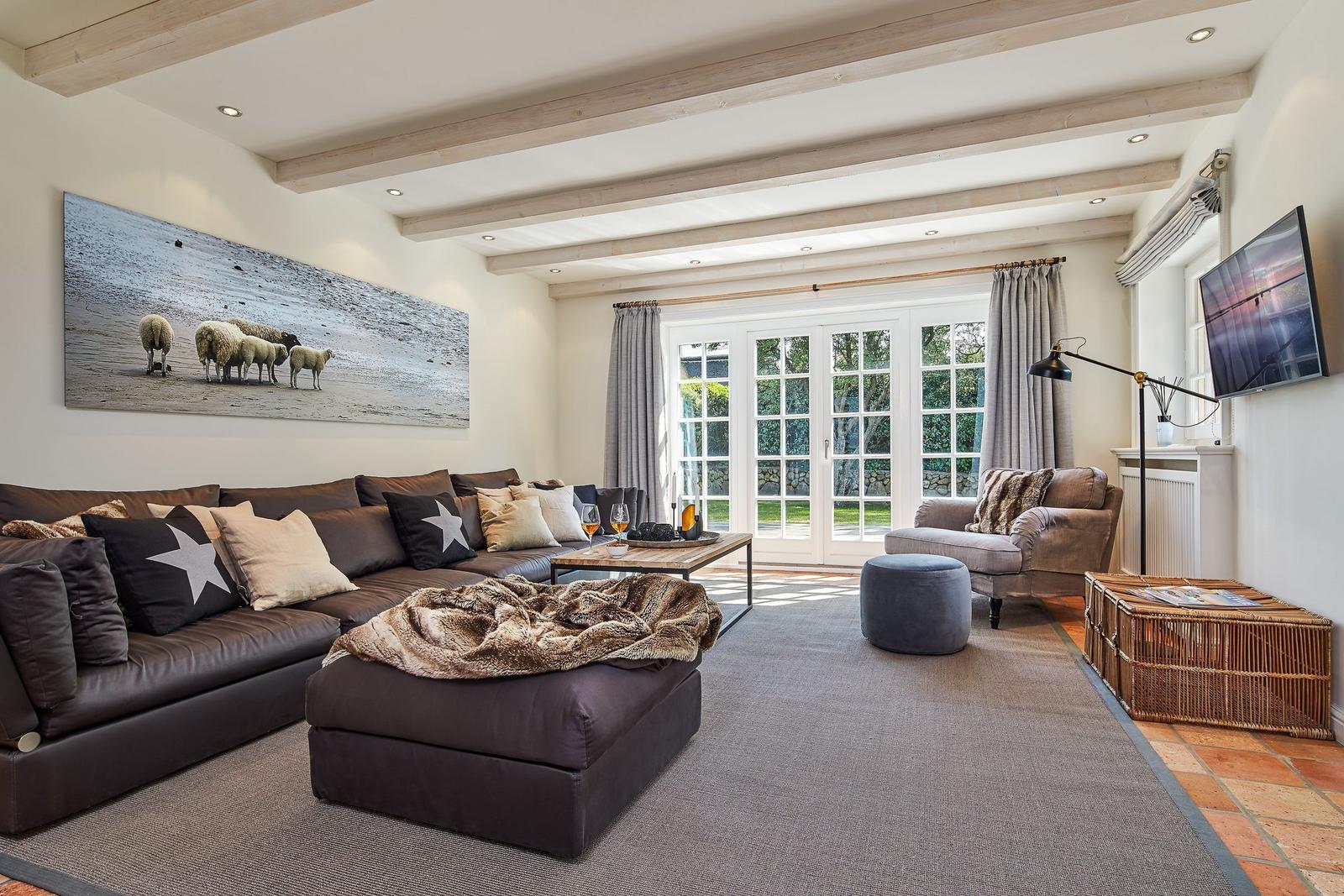 Living room with sofa, coffee table, and TV mounted on the wall.
