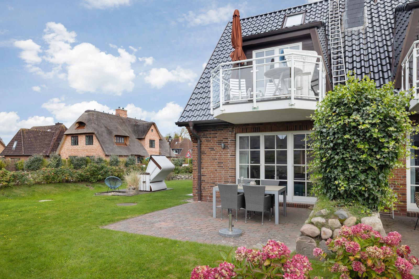 House with balcony, terrace and garden. Traditional houses in the background.