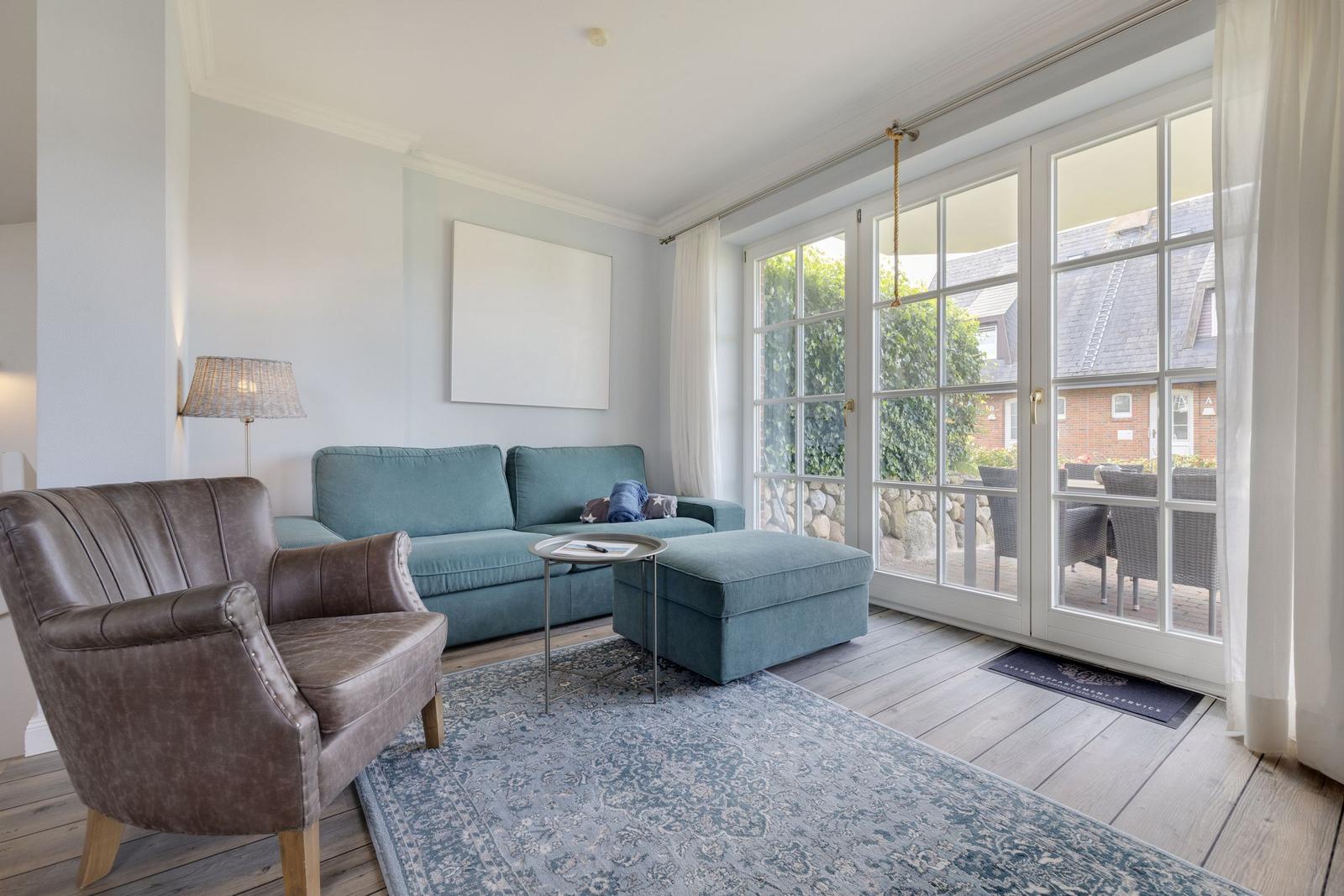 Living room with sofa, armchair, and terrace door