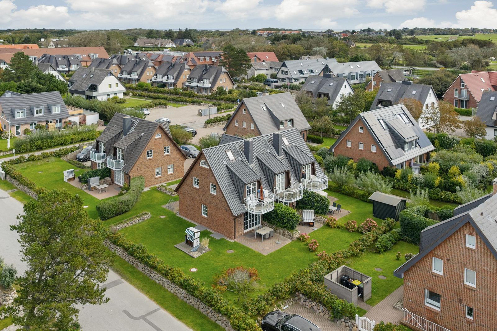 House with large garden and terrace. Surrounded by green areas and other houses.