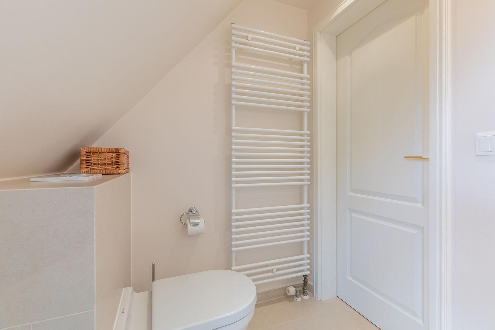 Bathroom with toilet, heater, and door