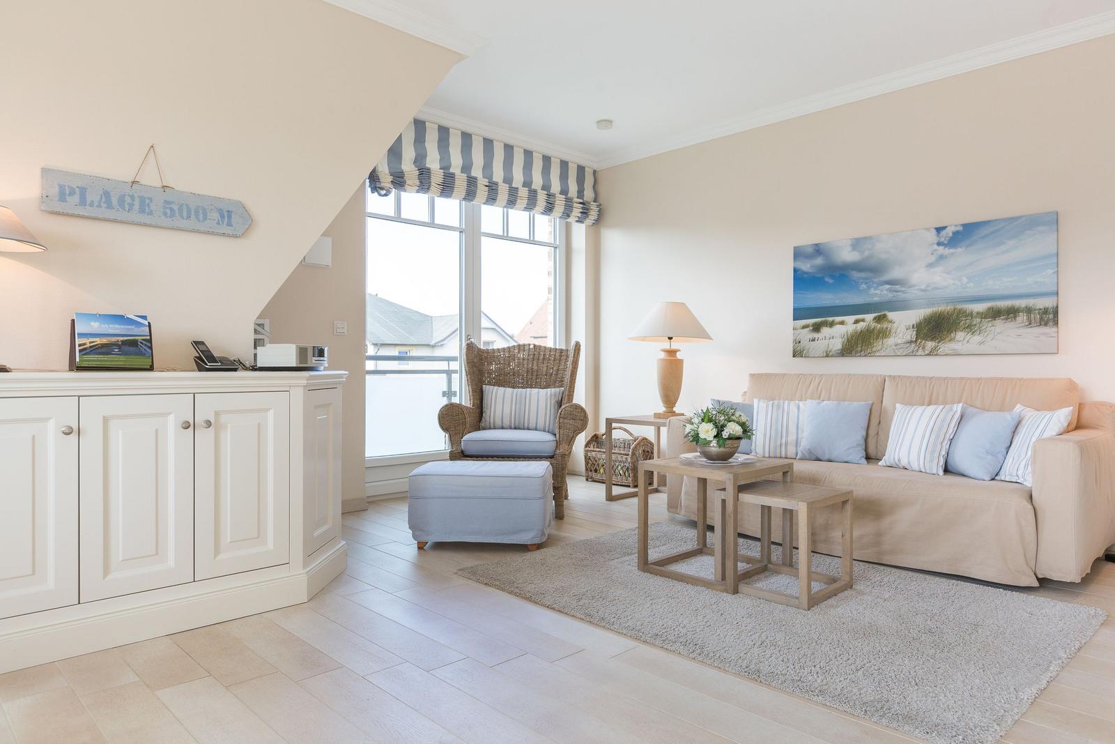 Wohnzimmer mit Sofa, Sessel und Fenster zur Aussicht