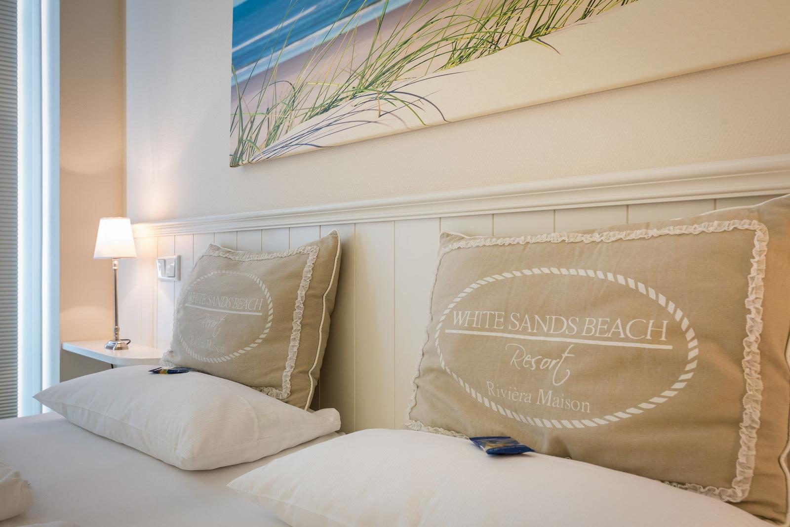 Bettkopf mit Kissen und Wandbild im Schlafzimmer