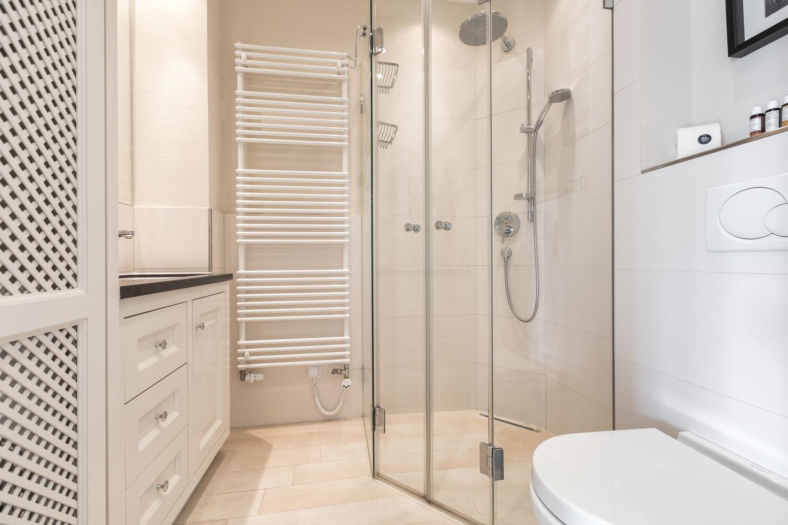 Badezimmer mit Dusche, Toilette und Waschbecken.