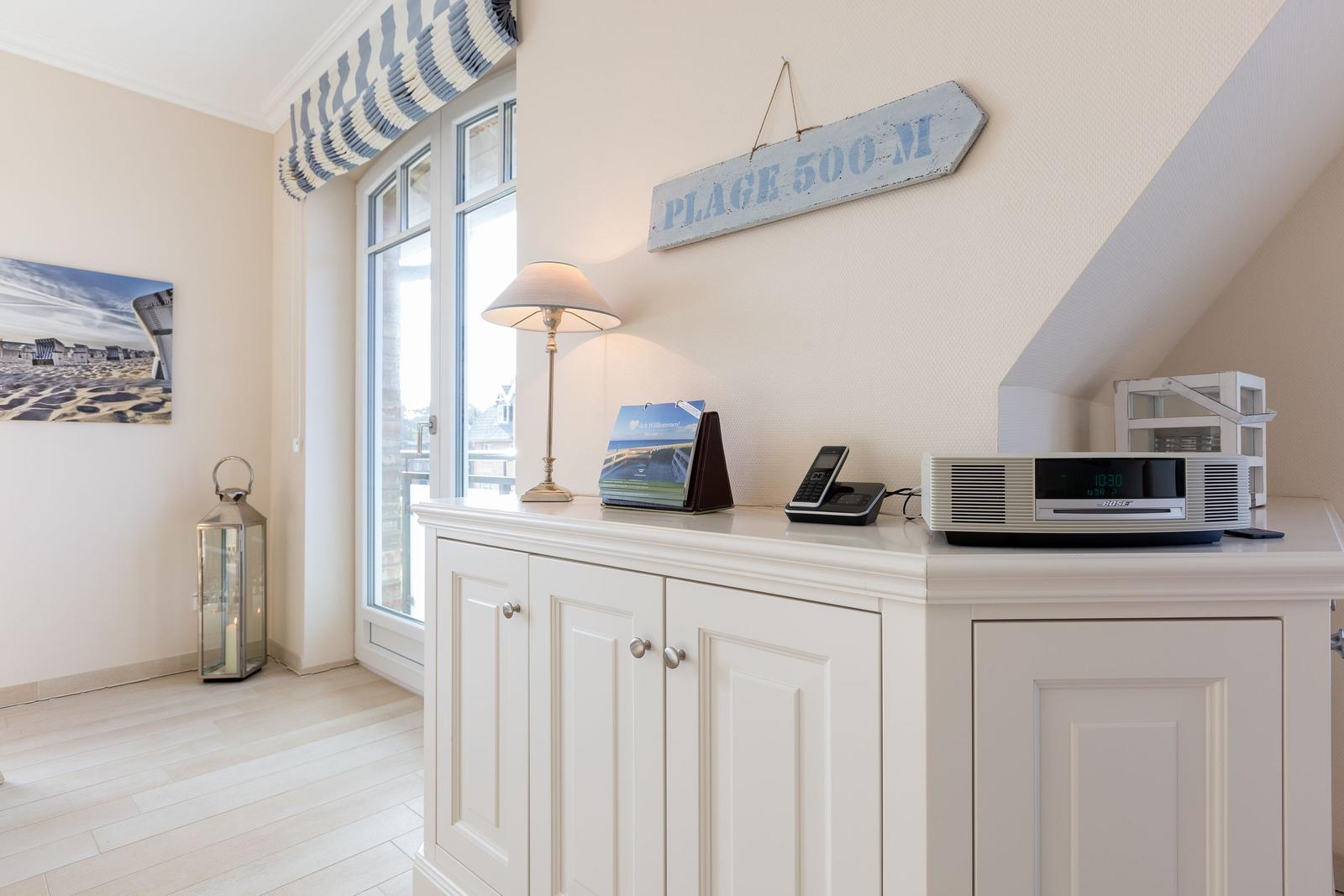 Wohnzimmer mit Fenster, Schrank und Wandbild